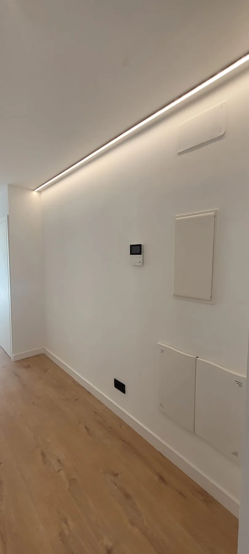 Detalle de una reforma interior con iluminación integrada y revestimientos claros